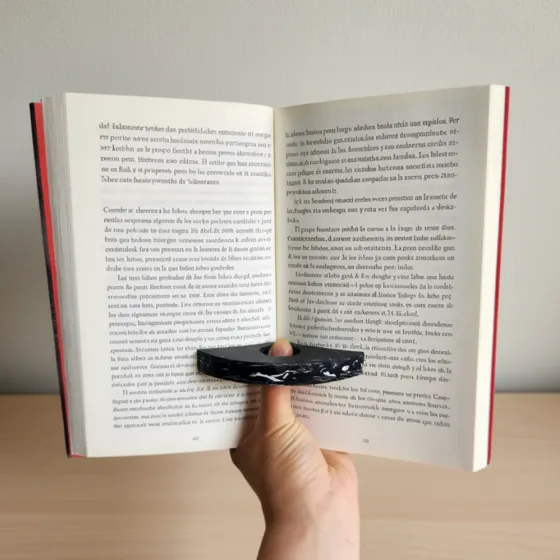 Separador de libros de plástico reciclado sosteniendo un libro abierto